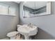 Cozy bathroom with a pedestal sink, mirrored cabinet, and a window for natural light at 16588 E 8Th Ave, Aurora, CO 80011
