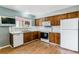 Well-lit kitchen with white appliances, ample countertop space, and classic wood cabinetry at 16588 E 8Th Ave, Aurora, CO 80011