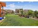 Large, landscaped backyard featuring lush green grass, wood fencing, decorative planters, and mountain views at 436 Sage Grouse Cir, Castle Rock, CO 80109