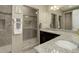 Bathroom featuring dual vanities, granite countertops, and a stylish tile shower with glass door at 436 Sage Grouse Cir, Castle Rock, CO 80109