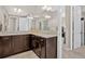 Spacious bathroom featuring granite countertops, dark wood cabinetry, and a large, bright mirror at 436 Sage Grouse Cir, Castle Rock, CO 80109