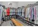 Walk-in closet provides generous storage with shelves for shoes, rows of hanging clothes, and a bench at 436 Sage Grouse Cir, Castle Rock, CO 80109