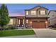 Two-story home with a brown garage door, stone accents, and a well-manicured lawn at 436 Sage Grouse Cir, Castle Rock, CO 80109