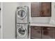 A compact laundry room features a stacked washer/dryer unit, cabinets, and a countertop for folding at 436 Sage Grouse Cir, Castle Rock, CO 80109