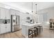 Bright kitchen with stainless steel appliances, breakfast bar, and modern pendant lighting fixtures at 6792 Navajo Way, Denver, CO 80221