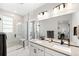 Modern main bathroom with dual sinks, sleek fixtures, a glass-enclosed shower, and contemporary finishes for a spa-like experience at 6792 Navajo Way, Denver, CO 80221