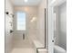 Stylish shower featuring tiled walls, a built-in bench, glass enclosure, and modern fixtures, offering a luxurious bathing experience at 6792 Navajo Way, Denver, CO 80221