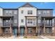 Modern townhome with gray and white siding, balcony, and a well-maintained front yard at 6814 Merseyside Ln, Castle Pines, CO 80108