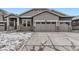 Charming home featuring stone accents, a three-car garage, and a well-maintained yard on a partially snowy day at 3877 Treadway Pt, Castle Rock, CO 80108