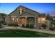 Inviting home features a covered porch, stone accents, and manicured front lawn at 6033 Trailhead Rd, Highlands Ranch, CO 80130