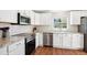 Well-lit kitchen featuring white cabinets, stainless steel appliances, and granite countertops with subway tile backsplash at 6033 Trailhead Rd, Highlands Ranch, CO 80130