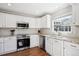 Modern kitchen featuring white cabinets, granite countertops, stainless steel appliances and natural light from window at 6033 Trailhead Rd, Highlands Ranch, CO 80130