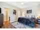 Spacious main bedroom with neutral tones, featuring a ceiling fan, ensuite bathroom, and decorative artwork at 6033 Trailhead Rd, Highlands Ranch, CO 80130