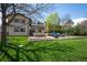 Expansive backyard with lush lawn, mature trees, a brick patio, and outdoor seating, perfect for relaxing and entertaining at 50 Meade Ln, Cherry Hills Village, CO 80113