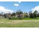 Lush backyard with a large grassy area, mature trees, and a charming home providing an outdoor haven at 50 Meade Ln, Cherry Hills Village, CO 80113