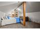 Bright bedroom under the eaves featuring a bed with blue accents and a cozy sitting area at 50 Meade Ln, Cherry Hills Village, CO 80113