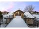 Outdoor bridge featuring stone columns, iron railings, and a horse weather vane on the roof at 50 Meade Ln, Cherry Hills Village, CO 80113