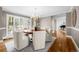 Elegant dining room featuring a round wood table, chandelier, hardwood floors, and large windows at 50 Meade Ln, Cherry Hills Village, CO 80113