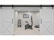 Bright exercise room featuring white sliding barn doors, an exercise bike, and free weights at 50 Meade Ln, Cherry Hills Village, CO 80113