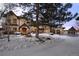 Elegant home featuring a circular driveway, multiple garages and a front lawn covered in fresh snow at 50 Meade Ln, Cherry Hills Village, CO 80113