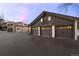 Spacious three-car garage with paneled doors attached to a home featuring stone accents and an upper patio at 50 Meade Ln, Cherry Hills Village, CO 80113