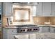 Kitchen with sleek stainless steel range, stone backsplash, granite countertops, and white cabinetry at 50 Meade Ln, Cherry Hills Village, CO 80113