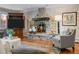 Living room with stone fireplace, wood paneled walls, and a large TV cabinet at 50 Meade Ln, Cherry Hills Village, CO 80113