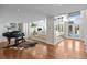Open-concept living room with hardwood floors, a fireplace, built-in shelving, and a grand piano at 50 Meade Ln, Cherry Hills Village, CO 80113