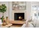 Cozy living room featuring an ornate fireplace, hardwood floors, and large windows overlooking the yard at 50 Meade Ln, Cherry Hills Village, CO 80113