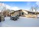 Rear patio covered in snow, with an outdoor table set for enjoying the picturesque winter scenery at 50 Meade Ln, Cherry Hills Village, CO 80113