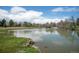 Scenic pond view with lush green grass and mature trees, offering a tranquil and picturesque setting at 50 Meade Ln, Cherry Hills Village, CO 80113
