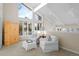 Bright sitting area featuring a vaulted ceiling, two chairs, a side table, and ample windows at 50 Meade Ln, Cherry Hills Village, CO 80113
