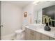 Contemporary bathroom with wood vanity, white sink and toilet at 1822 Grove St # 110, Denver, CO 80204