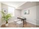 Bright home office with desk, two ottomans, and large plant at 1822 Grove St # 110, Denver, CO 80204