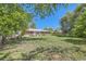 Spacious backyard with lush greenery, mature trees, and a charming brick house at 305 Cottonwood Ct, Longmont, CO 80501