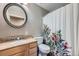 This bathroom has a granite countertop and a decorative shower curtain at 305 Cottonwood Ct, Longmont, CO 80501