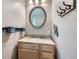 Well-lit bathroom with a granite vanity, round mirror, and practical storage, providing a clean and functional space at 305 Cottonwood Ct, Longmont, CO 80501