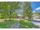 Charming single-story brick home with mature trees, a blue front door, and a well-manicured lawn at 305 Cottonwood Ct, Longmont, CO 80501