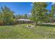 Beautiful front lawn with mature trees surrounding a brick ranch style home at 305 Cottonwood Ct, Longmont, CO 80501