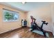 Home gym features a Peloton bike, hardwood floors, and natural light, encouraging an active lifestyle at 305 Cottonwood Ct, Longmont, CO 80501