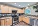 Well-lit kitchen featuring stainless steel appliances, light wood cabinets and tile flooring at 305 Cottonwood Ct, Longmont, CO 80501