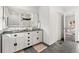 Modern bathroom with dual sink vanity, large mirror, neutral tile flooring, and updated fixtures at 1858 S Lincoln St, Denver, CO 80210
