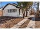 Charming exterior view of the home with painted white brick and tidy yard with an inviting walkway at 1858 S Lincoln St, Denver, CO 80210