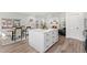 Open floor plan features a kitchen, dining area, and living room with bright, neutral decor and wood floors at 1858 S Lincoln St, Denver, CO 80210