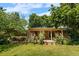 Lush backyard with mature trees, rose bushes, and a covered patio at 2698 S Niagara St, Denver, CO 80224