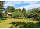 Mature backyard landscaping featuring trees, flowering bushes, and green grass at 2698 S Niagara St, Denver, CO 80224