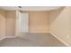 Unfinished basement space featuring neutral carpet, walls, and a door leading to another area at 2698 S Niagara St, Denver, CO 80224