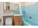 A retro bathroom featuring vintage blue tiling in the tub and light patterned wall paper at 2698 S Niagara St, Denver, CO 80224