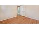 Bedroom featuring hardwood floors, neutral walls, closet, and a doorway leading to the bathroom at 2698 S Niagara St, Denver, CO 80224
