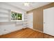 Bright bedroom featuring hardwood floors, large window with shelves, and built-in wall shelves at 2698 S Niagara St, Denver, CO 80224